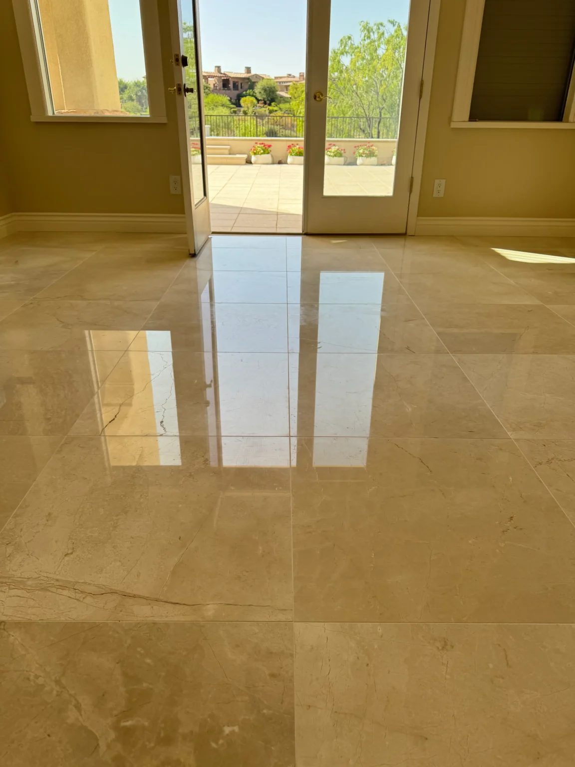 Polished marble floor reflecting light from open doors, showcasing restoration quality by Ultimate Finish Stone, Tile & Grout Inc.
